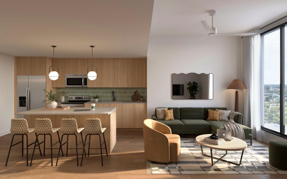 Modern open-concept Rambler Ann Arbor kitchen and living room with wood flooring, island and barstools, green sofa, armchair, round coffee table, floor lamp, large window, and neutral-colored decor.